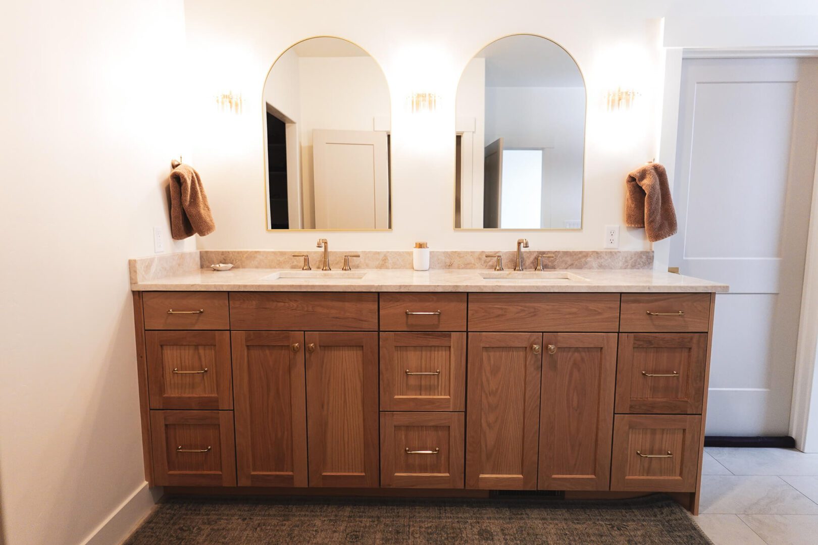 Double-sink wooden bathroom vanity with arched mirrors