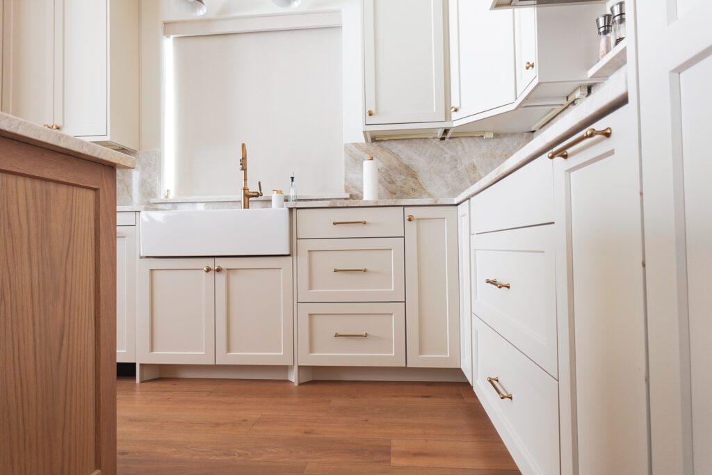 White farmhouse kitchen with brass faucet